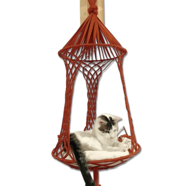 Cesto suspenso para gatos em formato de macramê laranja, com um gato relaxando no interior.