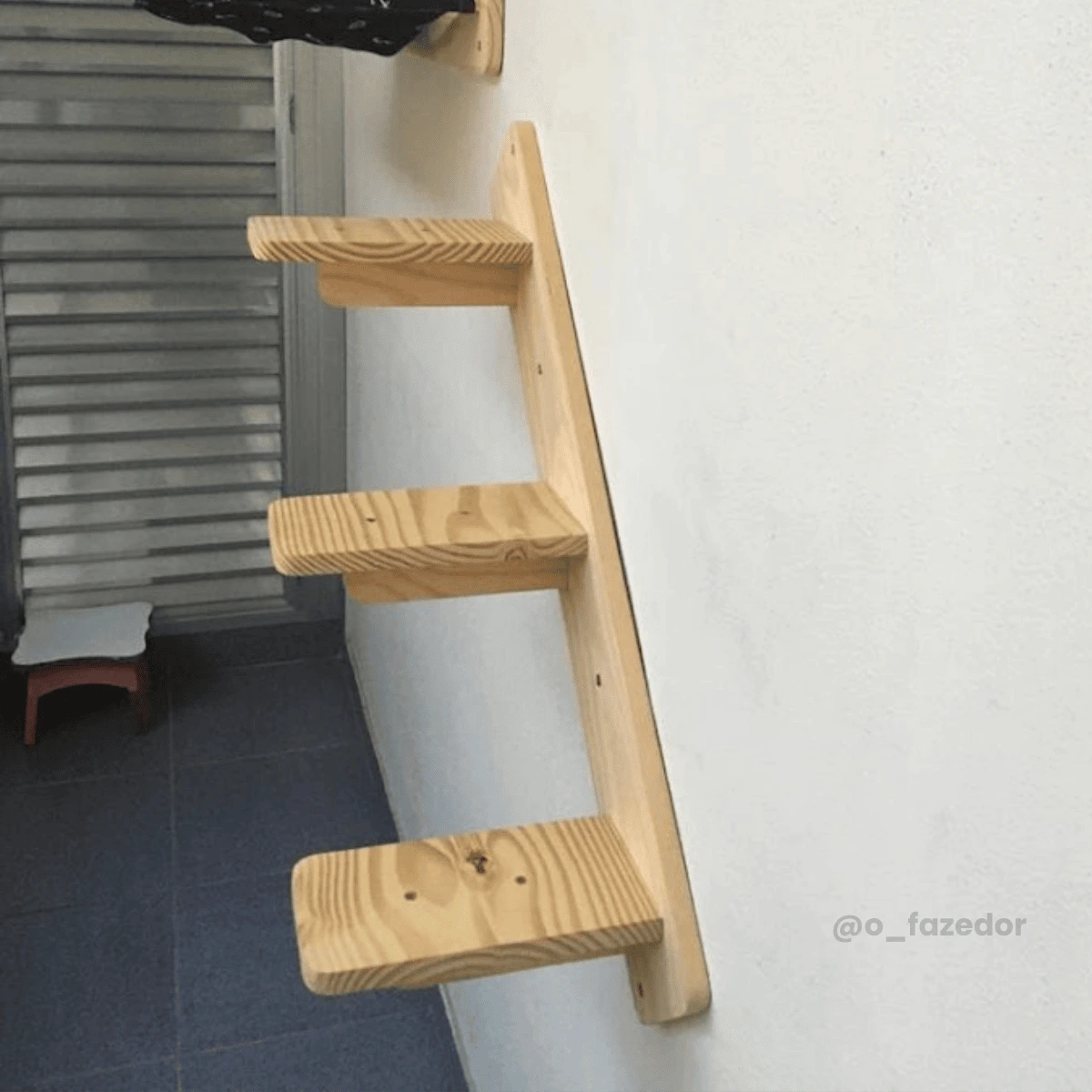Escada de madeira para gatos com três prateleiras fixadas na parede.