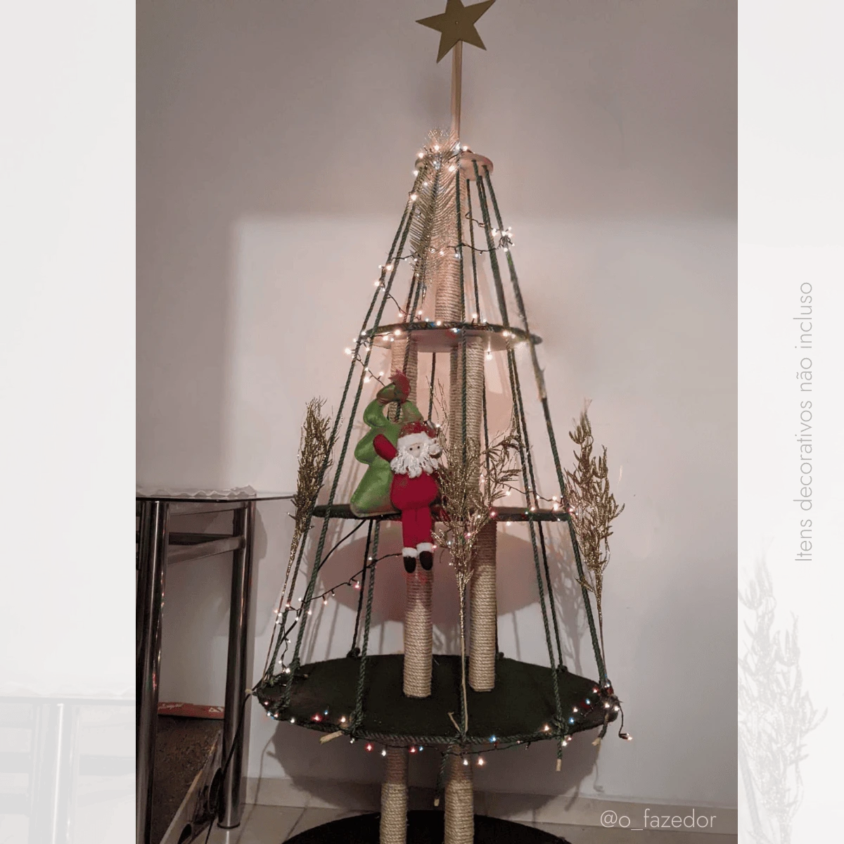 Árvore de cartão para gatos decorada com luzes e enfeites natalinos.
